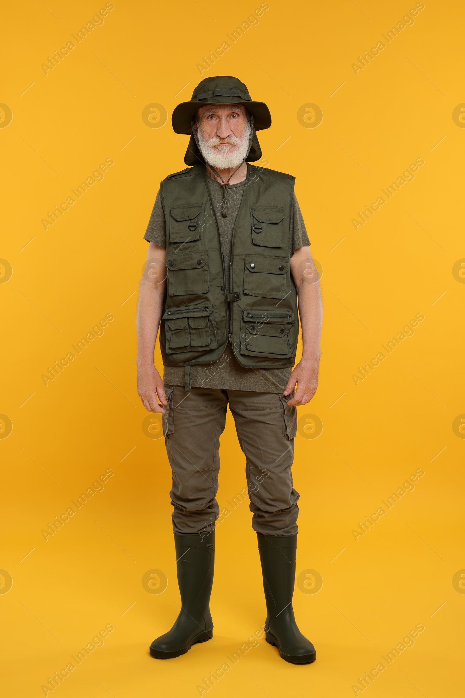 Photo of Portrait of fisherman in hat on yellow background