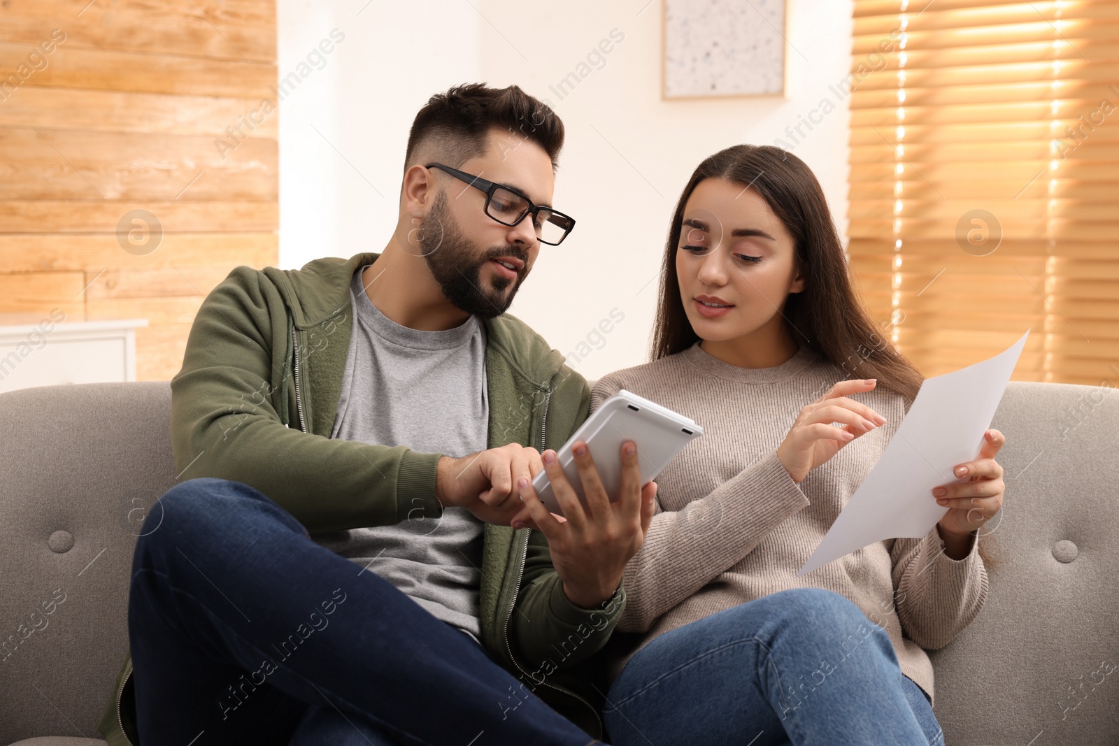 Photo of Young couple discussing family budget at home