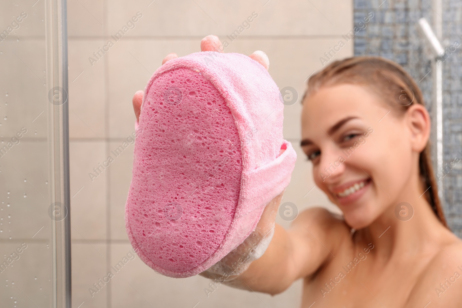 Photo of Young woman with pink sponge in shower