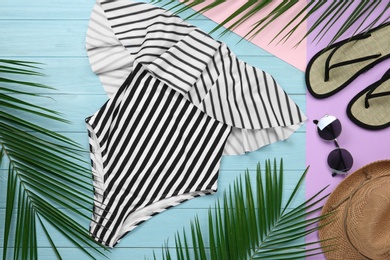 Photo of Flat lay composition with striped swimsuit and beach accessories on color background