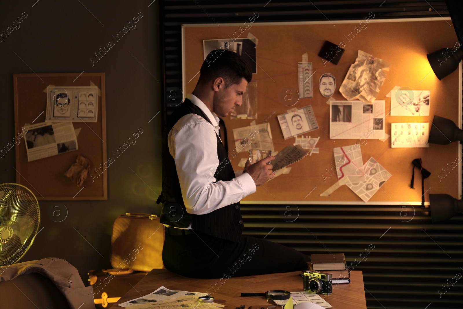 Photo of Old fashioned detective with documents near investigation board in office