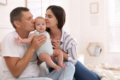 Happy family with their cute baby on bed at home