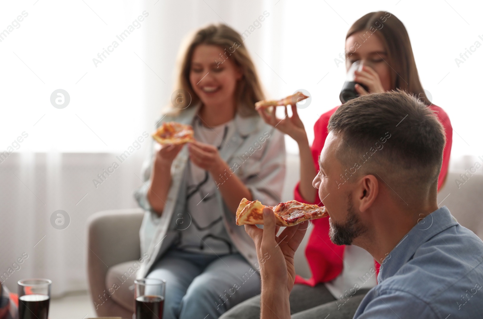 Photo of Group of friends eating tasty pizza at home