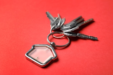 Photo of House keys with trinket on color background