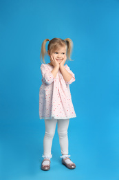 Portrait of cute little girl on blue background