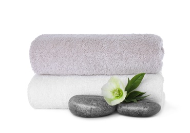 Photo of Towels, fresh flower and spa stones isolated on white