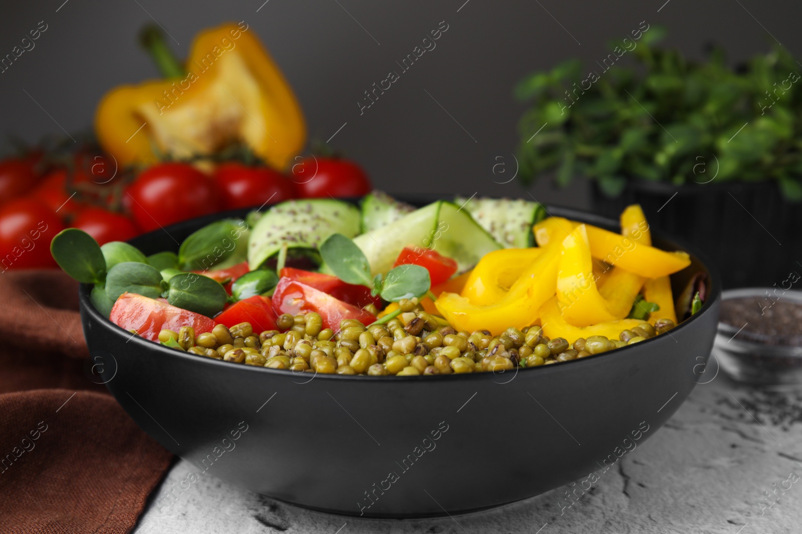 Photo of Bowl of salad with mung beans on white textured table