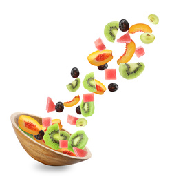 Image of Fresh tasty fruits and berries falling into bowl on white background