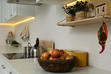 Photo of Fresh onions on countertop in modern kitchen