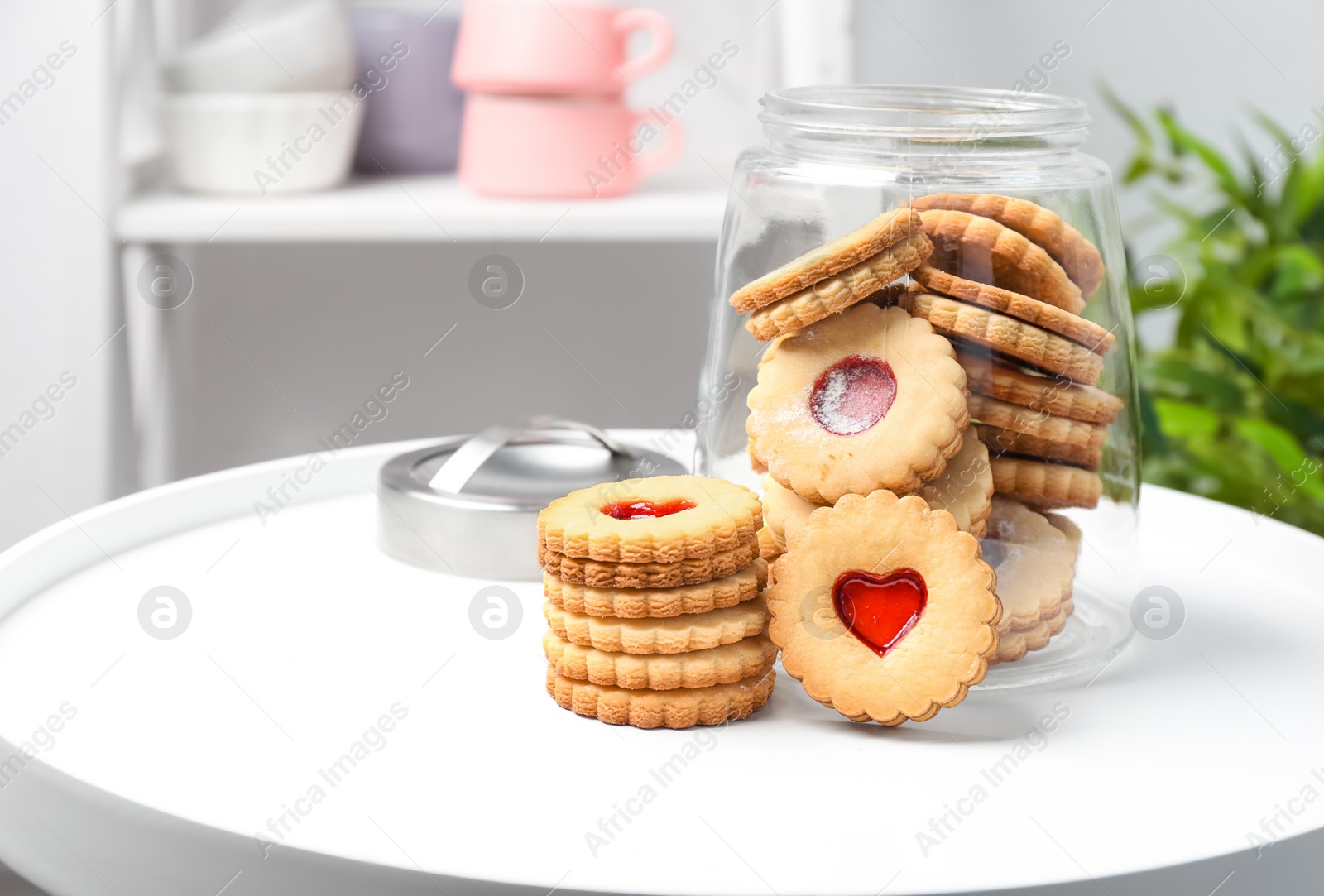 Photo of Traditional Christmas Linzer cookies with sweet jam and jar on table