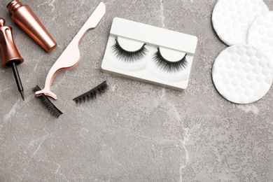 Photo of Flat lay composition with magnetic eyelashes and accessories on grey table. Space for text