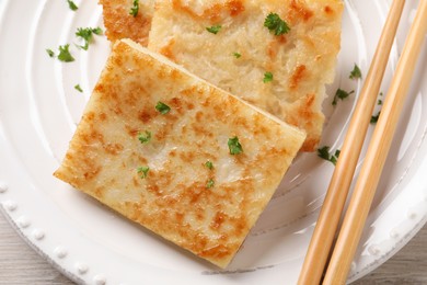 Photo of Delicious turnip cake with parsley on plate, top view