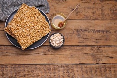Puffed rice bars (kozinaki) on wooden table, flat lay. Space for text