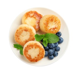 Delicious cottage cheese pancakes with blueberries, honey and mint on white background, top view