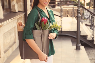 Woman with leather shopper bag near building, closeup