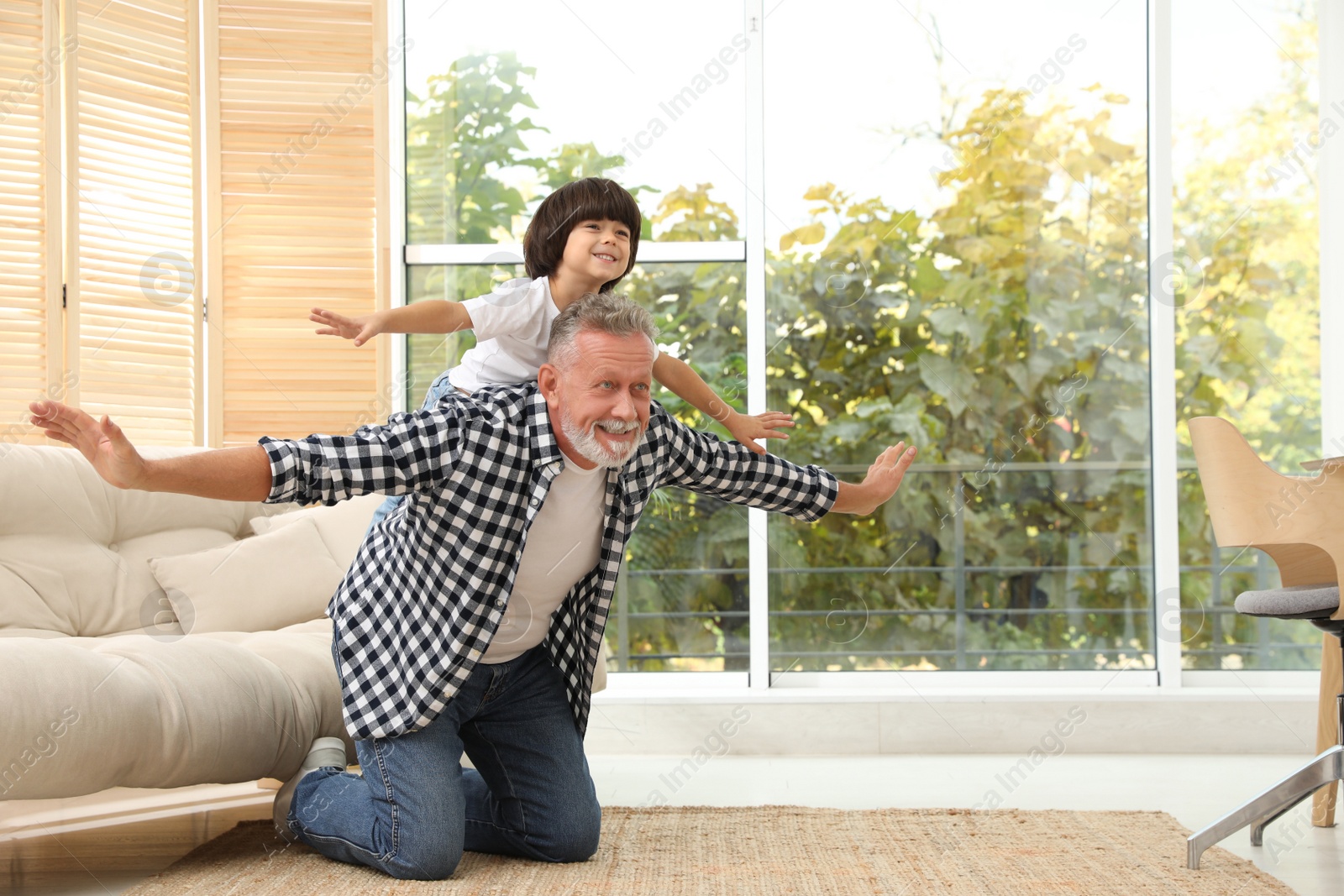 Photo of Happy grandfather with his grandson playing together at home