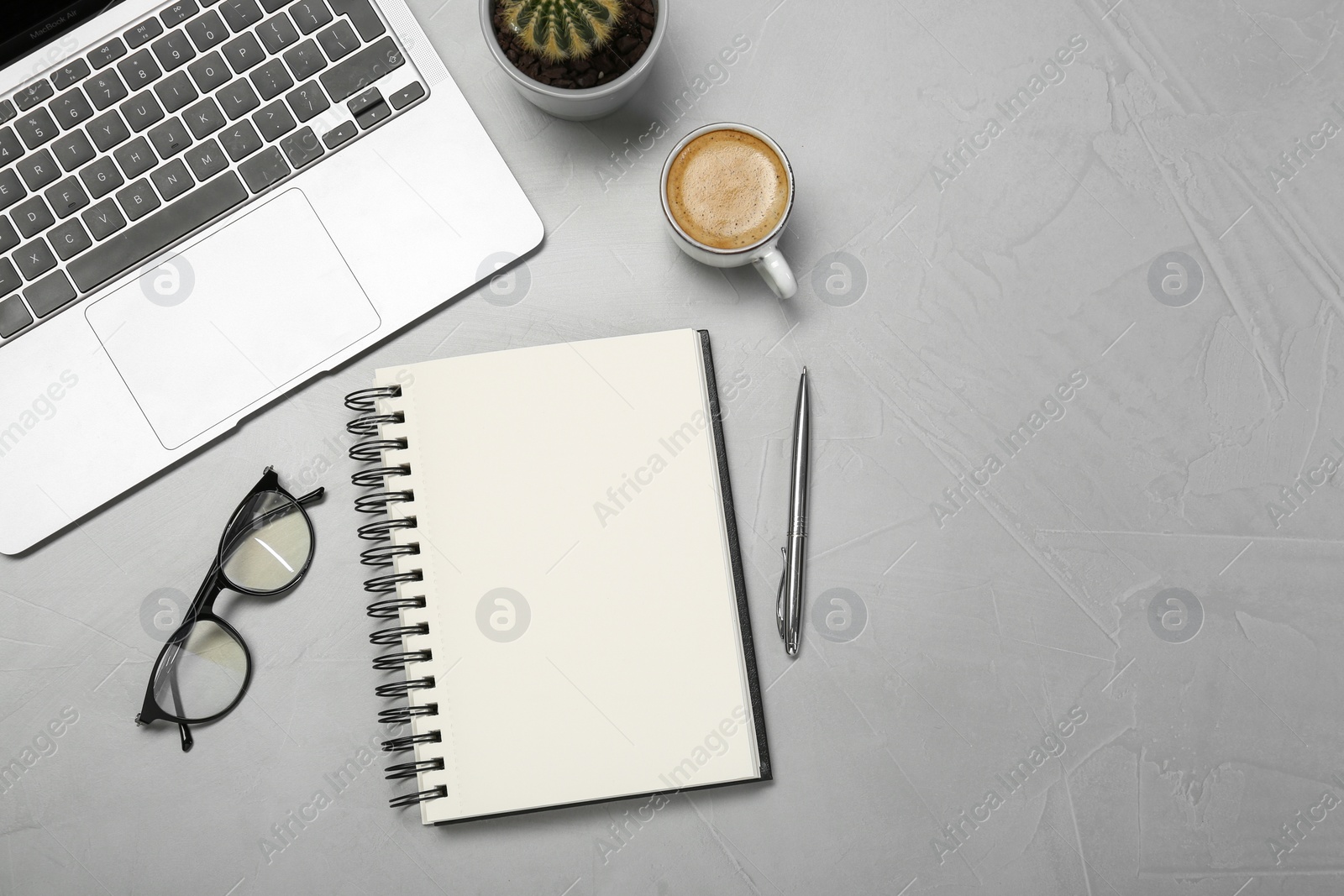 Flat lay composition with open notebook and laptop on light grey table Photo of Flat lay composition with open notebook and laptop on light grey table