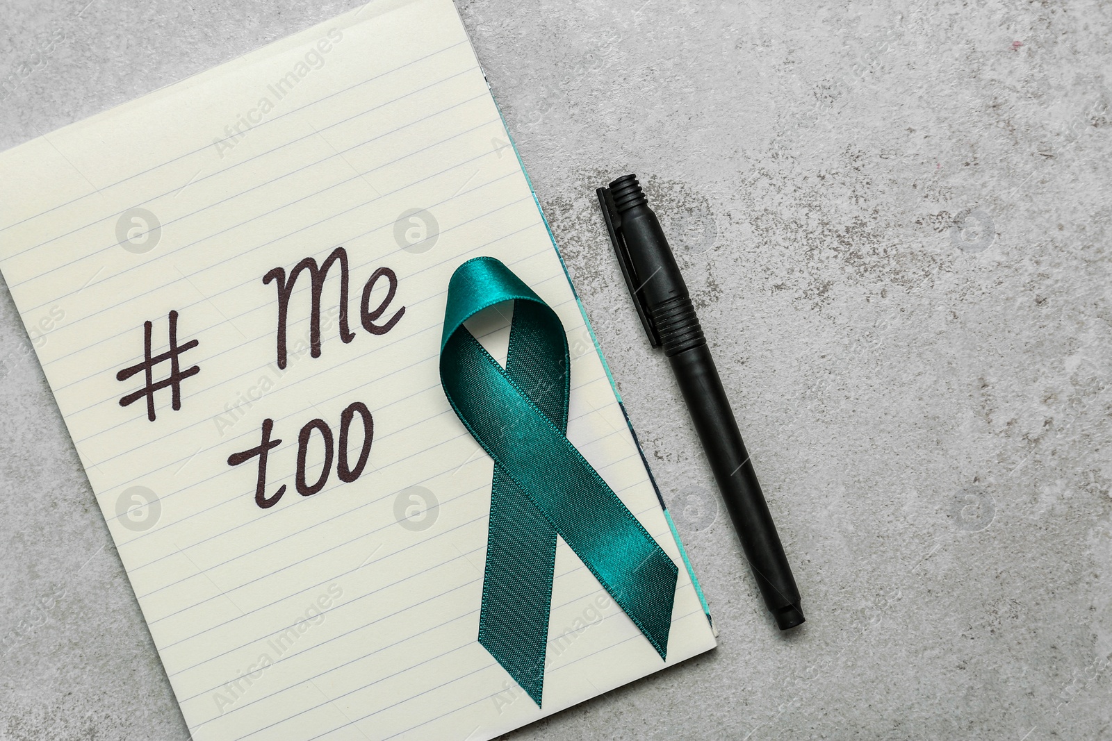 Photo of Teal awareness ribbon, pen and paper with hashtag METOO on grey background, flat lay. Stop sexual assault