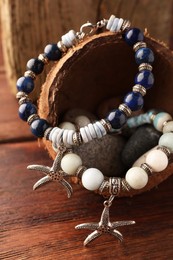 Photo of Stylish presentation of beautiful bracelets with gemstones on wooden table, closeup