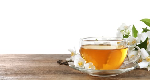 Photo of Glass cup of aromatic jasmine tea and fresh flowers on wooden table against white background. Space for text