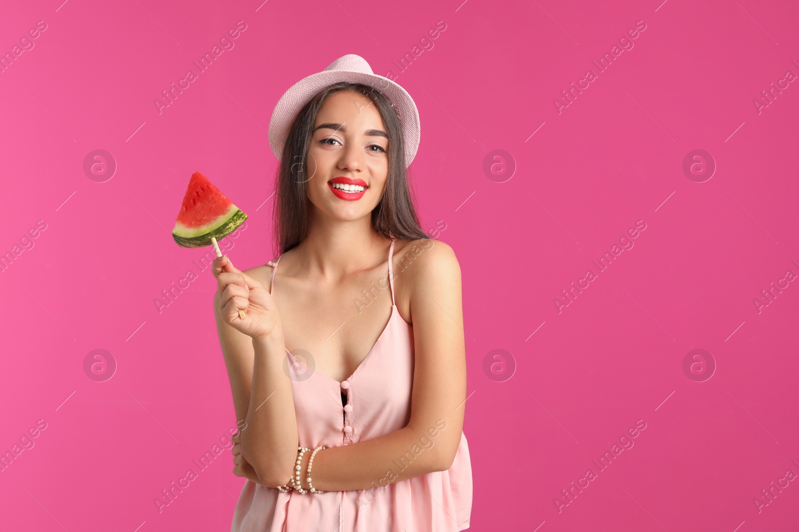 Photo of Beautiful young woman posing with watermelon on color background