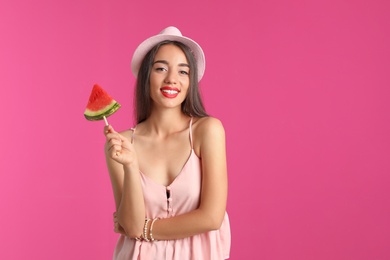 Photo of Beautiful young woman posing with watermelon on color background