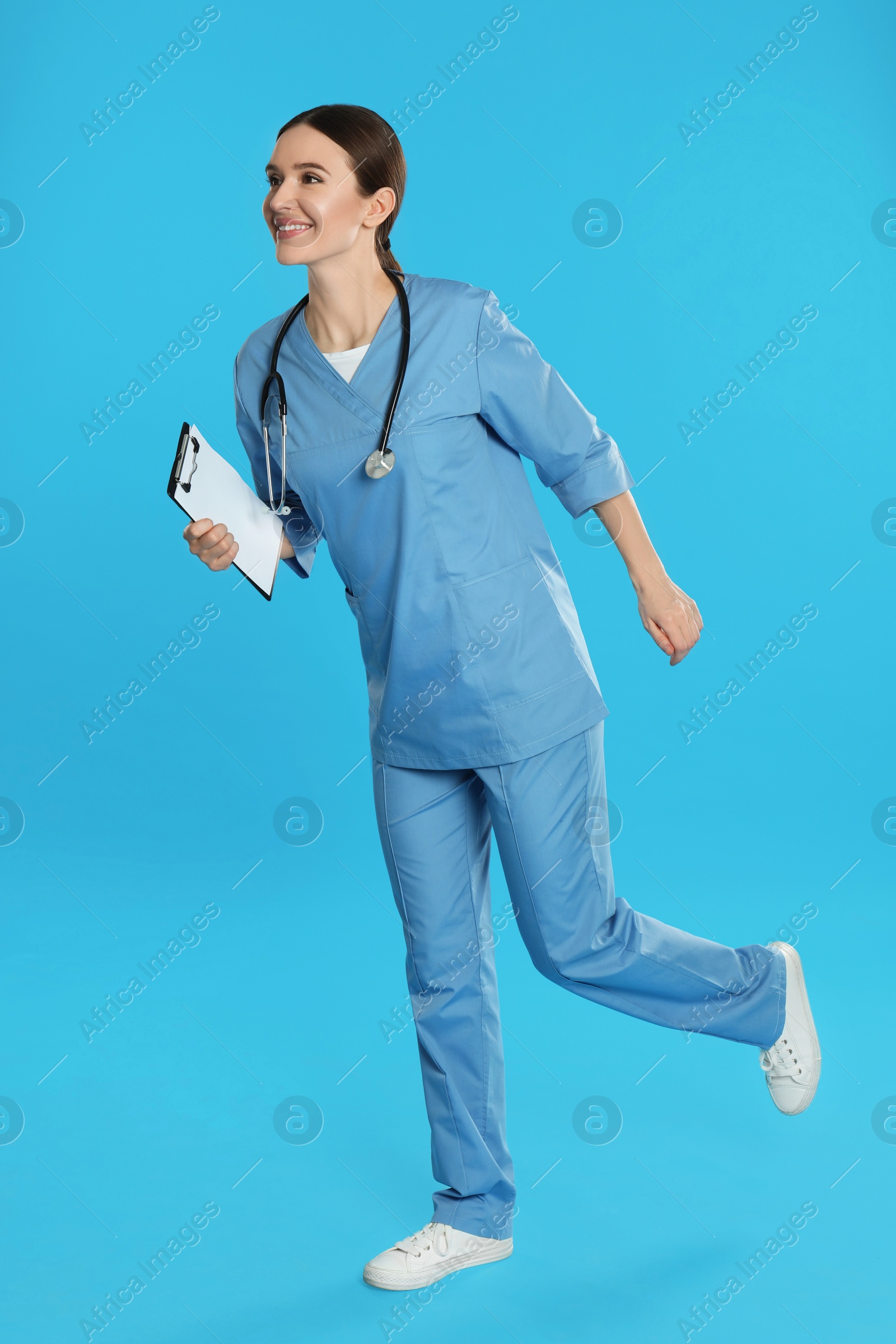 Photo of Doctor with clipboard and stethoscope running on blue background