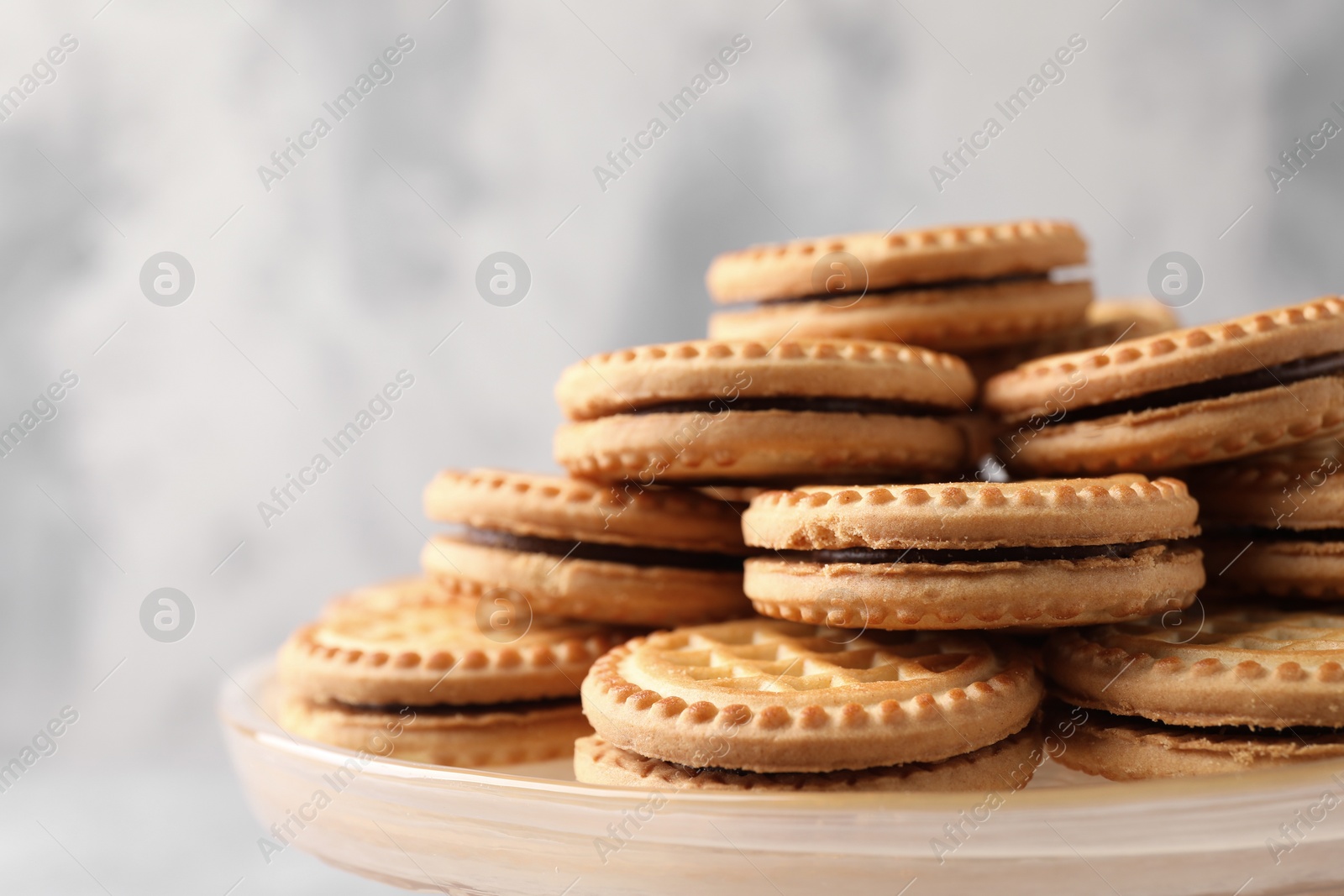 Photo of Tasty sandwich cookies with cream on tray, closeup. Space for text