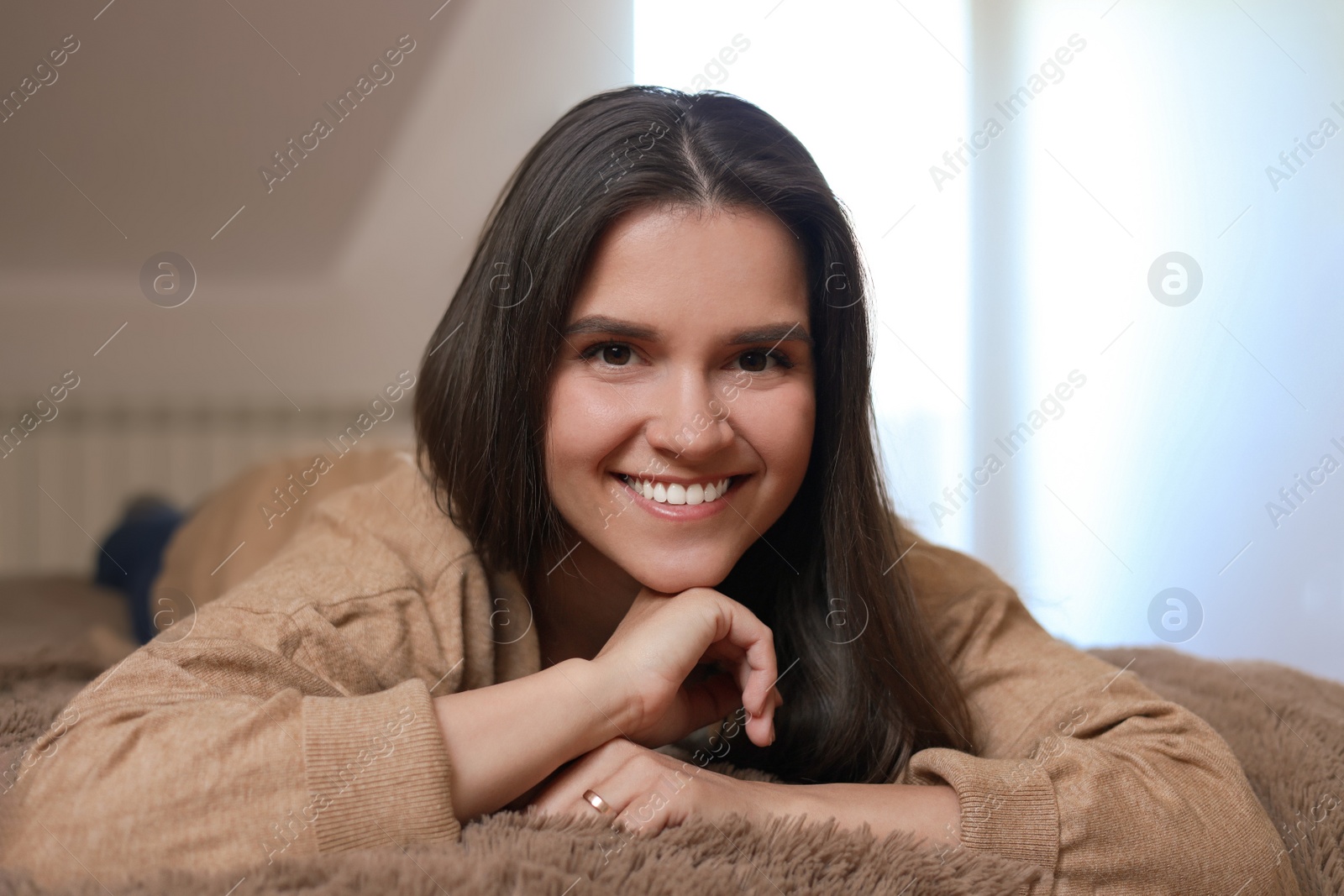 Photo of Portrait of beautiful young woman lying on bed at home