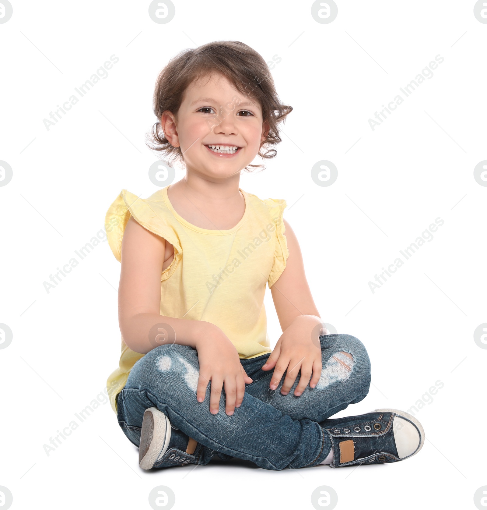 Photo of Cute little girl in casual outfit sitting on white background