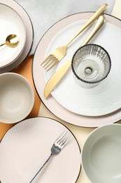 Photo of Clean plates, bowls, glass and cutlery on table, flat lay