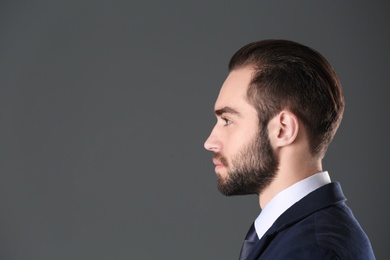 Photo of Portrait of young businessman with beautiful hair on grey background