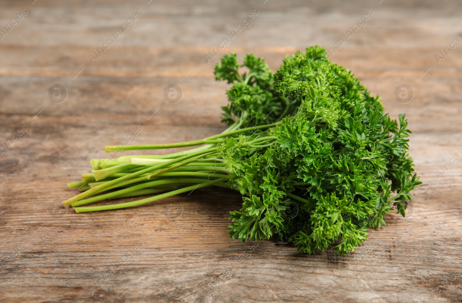 Photo of Bunch of fresh green parsley on wooden table