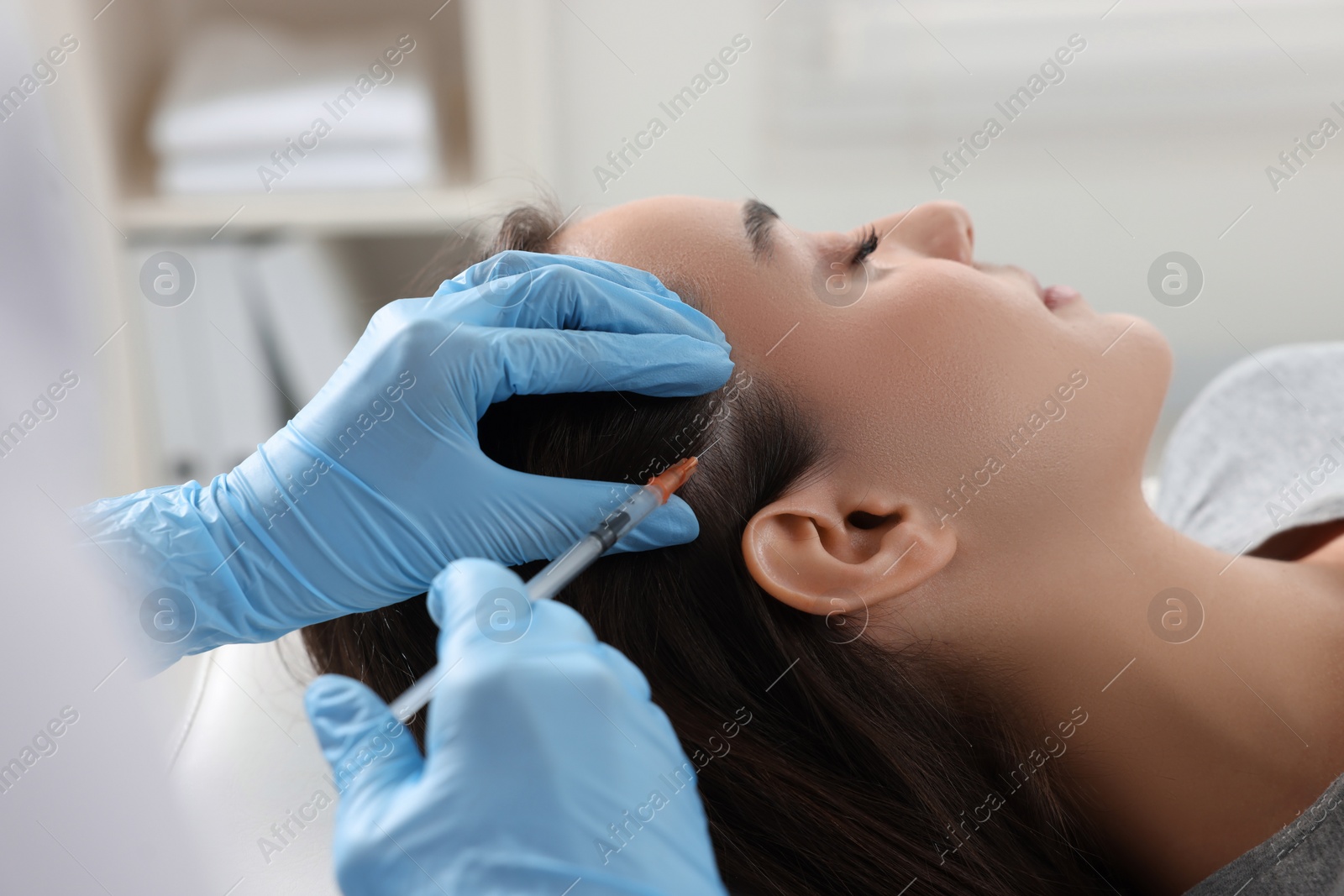 Photo of Trichologist giving injection to patient in clinic, closeup