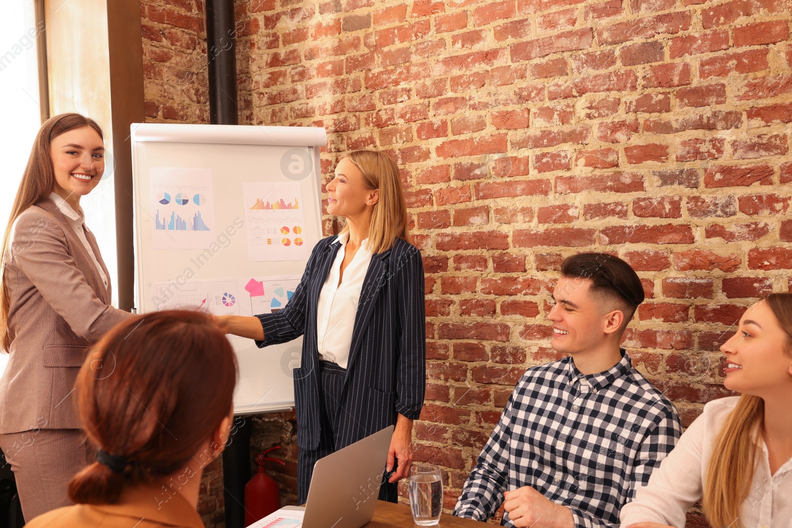 Photo of Businesswoman having meeting with her employees in office. Lady boss