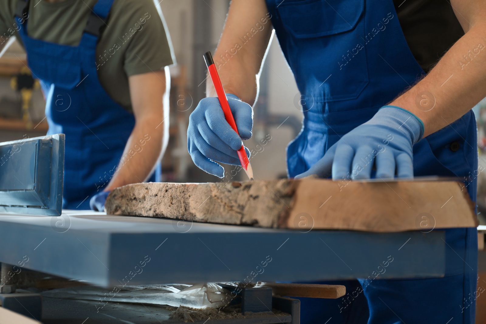 Photo of Professional carpenters working with wood in shop, closeup
