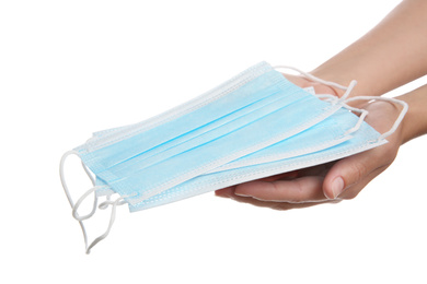 Woman holding disposable face masks on white background, closeup. Protective measures during coronavirus quarantine