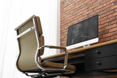 Photo of Stylish workplace interior with modern office chair