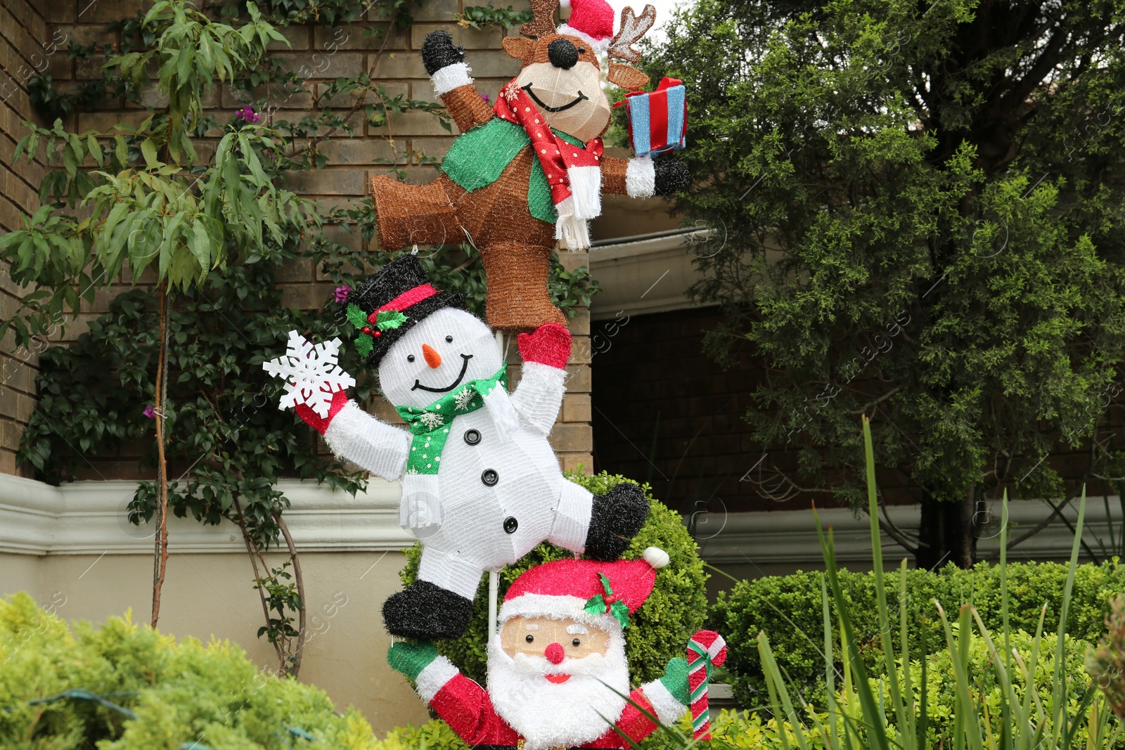 Photo of Funny reindeer, snowman and Santa Claus outdoors. Festive Christmas decoration