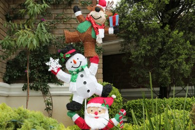 Photo of Funny reindeer, snowman and Santa Claus outdoors. Festive Christmas decoration