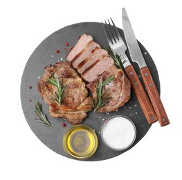Photo of Pieces of delicious fried meat served with rosemary, oil and spices on white background, top view