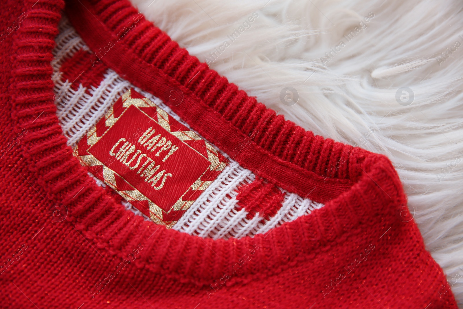 Photo of Christmas sweater with tag on fur, closeup