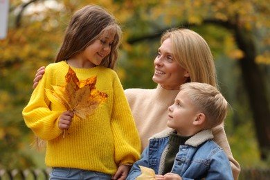 Photo of Happy mother with her children in autumn park