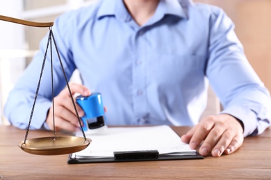Photo of Scales of justice and blurred view of notary on background