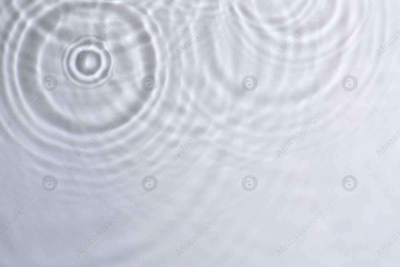 Photo of Closeup view of water with circles on light background