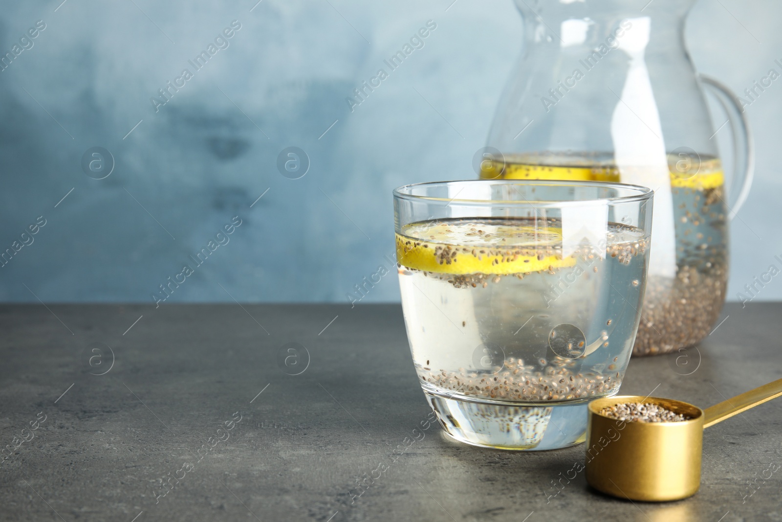 Photo of Glass of water with chia seeds and lemon on table. Space for text