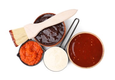 Photo of Different marinades and basting brush isolated on white, top view