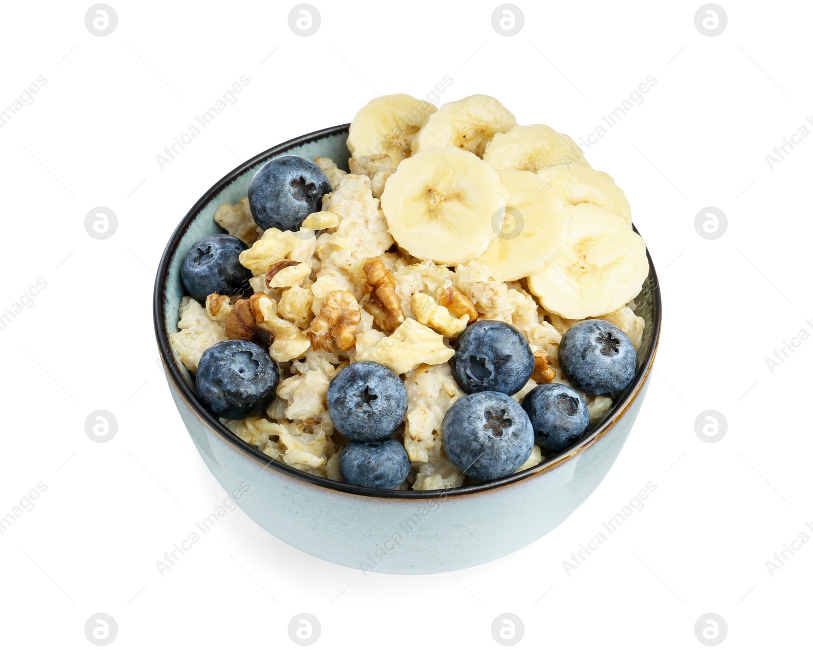 Photo of Tasty oatmeal with banana, blueberries and walnuts in bowl isolated on white