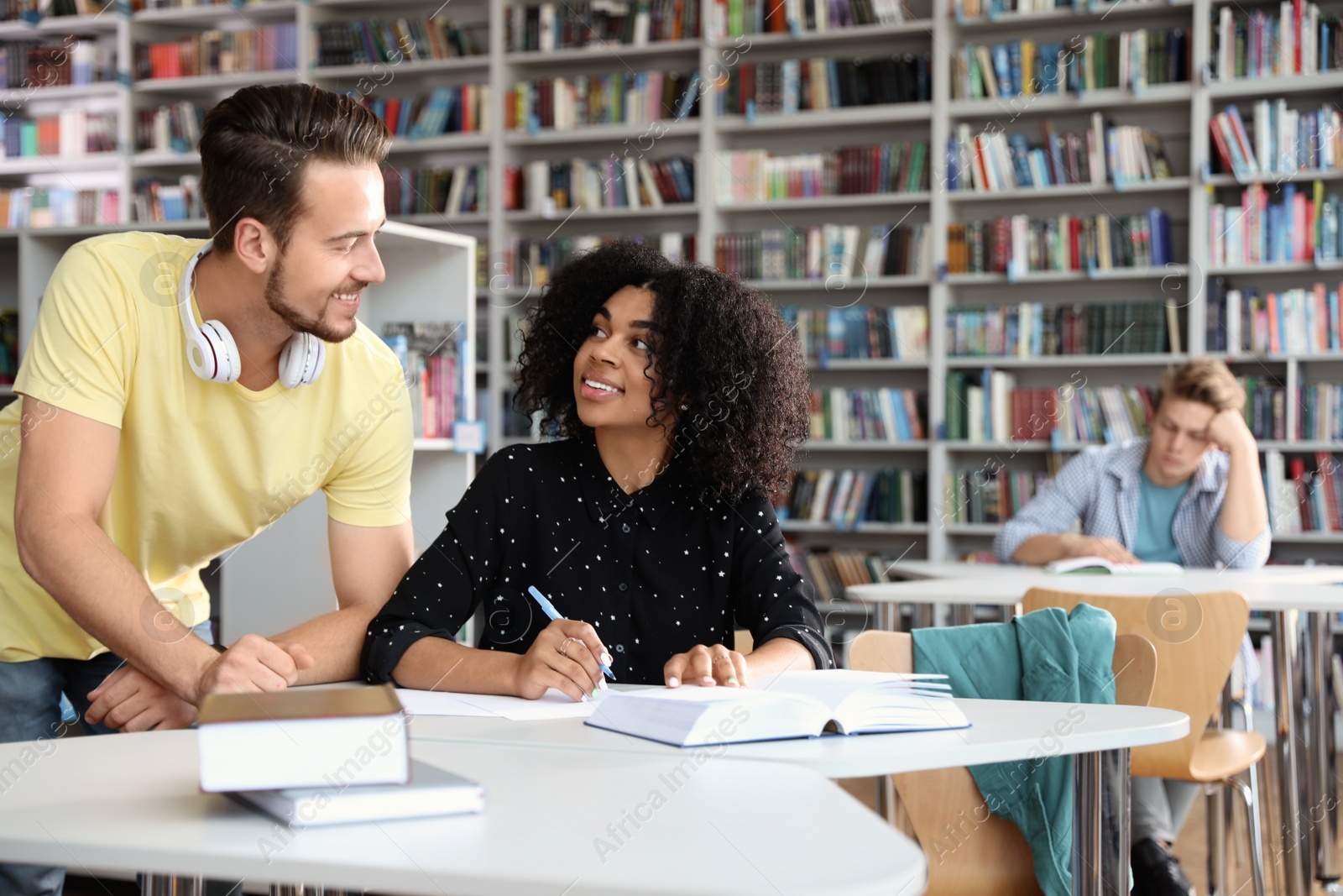 Photo of Young people studying at table in library