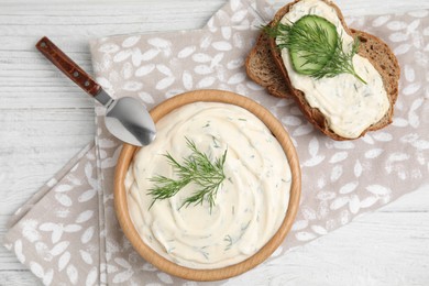 Tasty creamy dill sauce and sandwich on white wooden table, flat lay